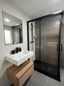 a bathroom with a white sink and a shower at MSuites Viveiro in Viveiro