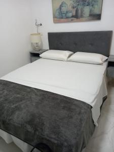 a large bed with white sheets and pillows at Jerusalem M in Jerusalem