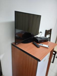 une télévision sur une table en bois avec deux télécommandes dans l'établissement Jerusalem M, à Jérusalem