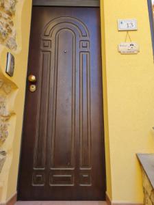 a brown door in a building with a sign on it at Palazzo B&B in Trentinara