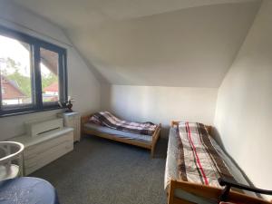 a attic room with two beds and a window at Kaszuby Dom Letniskowy -u Remika- Holiday Home Sulęczyno in Å»akowo