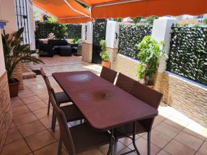 une table et des chaises sur une terrasse agrémentée de plantes dans l'établissement Alojamiento Los Corrales, à Chipiona