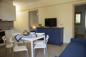 cocina y comedor con mesa y armario azul en Case Vacanze Baia, en Realmonte