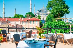 a patio with tables and chairs with a view of a mosque at Sarnic Hotel & Sarnic Premier Hotel(Ottoman Mansion) in Istanbul