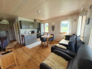 a living room with a couch and a table and a kitchen at Kalda Holiday Home in Otepää