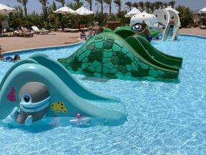 a water slide in a pool at a water park at Dream Lagoon Resort & Aqua Park in Marsa Alam City