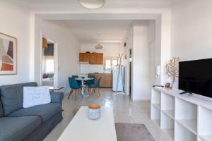 a living room with a couch and a tv at Lovely Apartment Close To The City Center in Heraklio