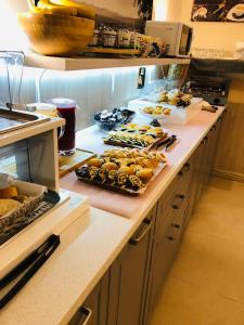 un bancone della cucina con molti tipi di cibo diversi di Hotel Cantore a Genova