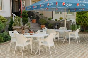 einen Tisch, Stühle und einen Regenschirm auf einer Terrasse in der Unterkunft Guest House Sofia in Kobuleti