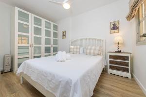 Dormitorio blanco con cama blanca y vestidor en WintoWinRentals Genial Apartamento, Céntrico y Silencioso, en Málaga