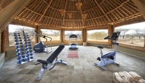 - une salle de sport avec plusieurs vélos d'exercice dans un bâtiment dans l'établissement Severin Safari Camp, à Tsavo West National Park