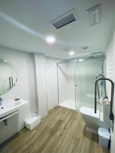 uma casa de banho com um chuveiro, um WC e um lavatório. em Hotel Faro de Finisterre em Finisterre