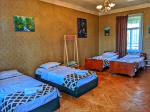 a room with three beds in a room at Veli Guest House • საოჯახო სასტუმრო ველი in Zemo Alvani