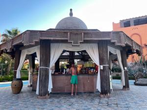 a man standing at a bar in a kiosk at Dream Lagoon Resort & Aqua Park in Marsa Alam City
