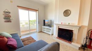a living room with a fireplace and a tv at Apartamento Sol do Amanhã in Santa Cruz