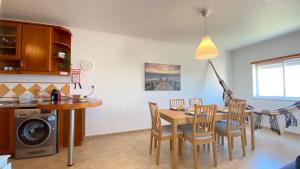 a kitchen and dining room with a table and chairs at Apartamento Sol do Amanhã in Santa Cruz