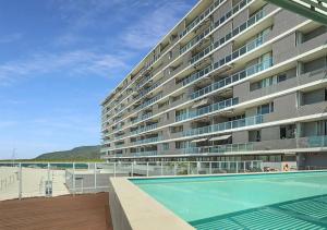 a large apartment building with a swimming pool in front of it at Lovely One Bedroom Apartment "Cairns Harbour Lights" in Cairns