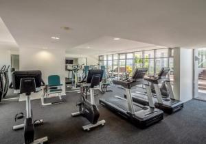 a gym with several treadmills and exercise bikes at Lovely One Bedroom Apartment "Cairns Harbour Lights" in Cairns