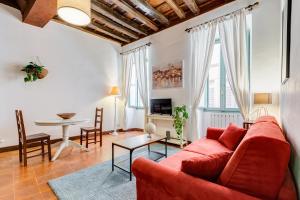un salon avec un canapé rouge et une table dans l'établissement Romantic Pantheon Lovely&Quiet, à Rome