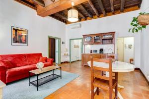 un salon avec un canapé rouge et une table dans l'établissement Romantic Pantheon Lovely&Quiet, à Rome