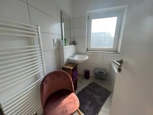 a bathroom with a chair and a sink and a window at Suite 110qm nahe Rhein in Krefeld +22 photos