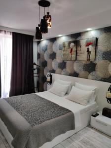 Un dormitorio con una cama blanca y una pared con sombrillas. en Tbilisi App 1 en Tiflis