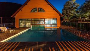 a house with a swimming pool in front of a house at Résidence Les Trois Vallées - ARREAU in Arreau