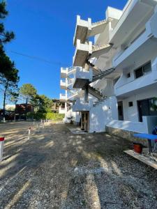 a large white building with a lot at Aparthotel Vila Tufi in Velipojë