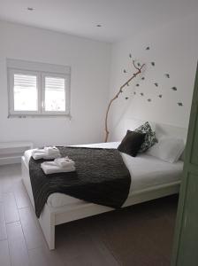 a bedroom with a bed with a branch on the wall at Eira da Mila in Coimbra