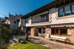 un edificio con un banco delante de él en Casa rural Paco En pleno corazón de Cantabria muy cerca de la costa, en Carranceja