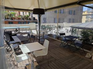 un patio con mesas y sillas en la azotea en Hotel Cantore, en Génova