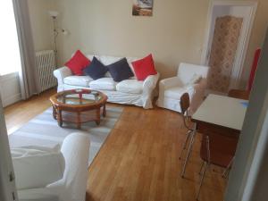 Una sala de estar con un sofá blanco y una mesa. en La Petite Cerise, en Eymoutiers