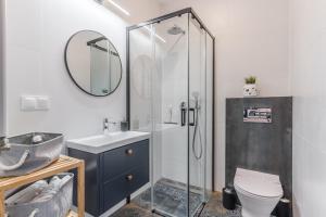 a bathroom with a shower and a toilet and a sink at Sapphire Premium Apartment in Grudziądz +24 photos