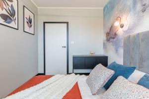 a bedroom with a bed with blue pillows at Sapphire Premium Apartment in Grudziądz