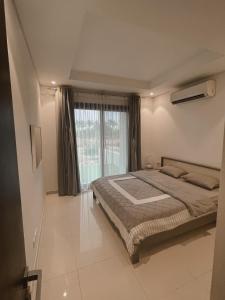 a bedroom with a bed and a large window at almuzn in Salalah +17 photos