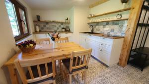 a kitchen with a wooden table with a vase of fruit at Apartmán U Profesora in Staré Město