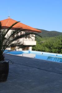 a building with a swimming pool next to a resort at Бадевски рай-къща Любов in Badewzi