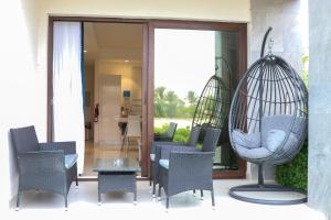 a patio with chairs and a hanging swing at almuzn in Salalah