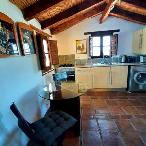 a kitchen with a glass table in a room at Attico Los Montes with private pool in Viñuela