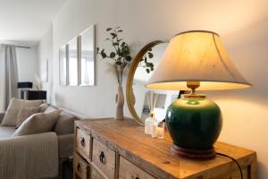 a lamp on a wooden table with a mirror at SHS HOMES-LUXE HIGHRISE, 2 BEDROOMS, KITCHEN, FREE PARKING, STUNNING VIEW, LARGE TARRASSE, Workspace in Hasselt