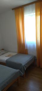 a bedroom with two twin beds and a window at Apartments Mara Seget Vranjica in Seget Vranjica