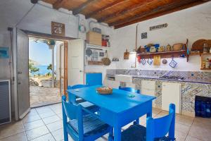 サン・ヴィート・ロ・カーポにあるRustico Zingaroの青いテーブルと椅子が備わるキッチン