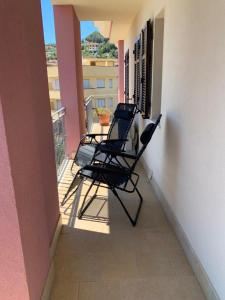 3 chaises assises sur le balcon d'un bâtiment dans l'établissement Casa del Grillo, à Costarainera