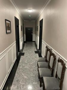 un pasillo con una fila de sillas y una puerta negra en Katowice Gallery Center en Katowice