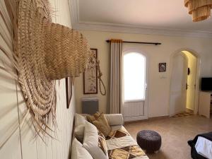 uma sala de estar com um sofá e um lustre em Dar Macha em Ghazoua