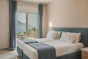 a bedroom with a large bed with a large window at Montagna & Mare villa in Kefallonia +31 photos