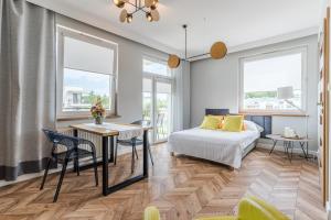 1 dormitorio con 1 cama, mesa y sillas en Copper Apartment, en Grudziądz
