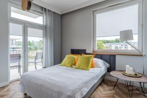 sypialnia z łóżkiem z żółtymi poduszkami i stołem w obiekcie Copper Apartment w Grudziądzu