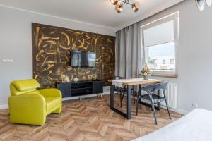 un salon avec une table et une chaise jaune dans l'établissement Copper Apartment, à Grudziądz
