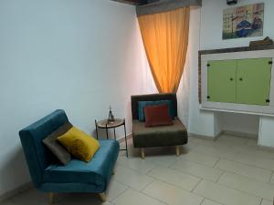 a living room with two chairs and a tv at Casetta Vigo in Chioggia